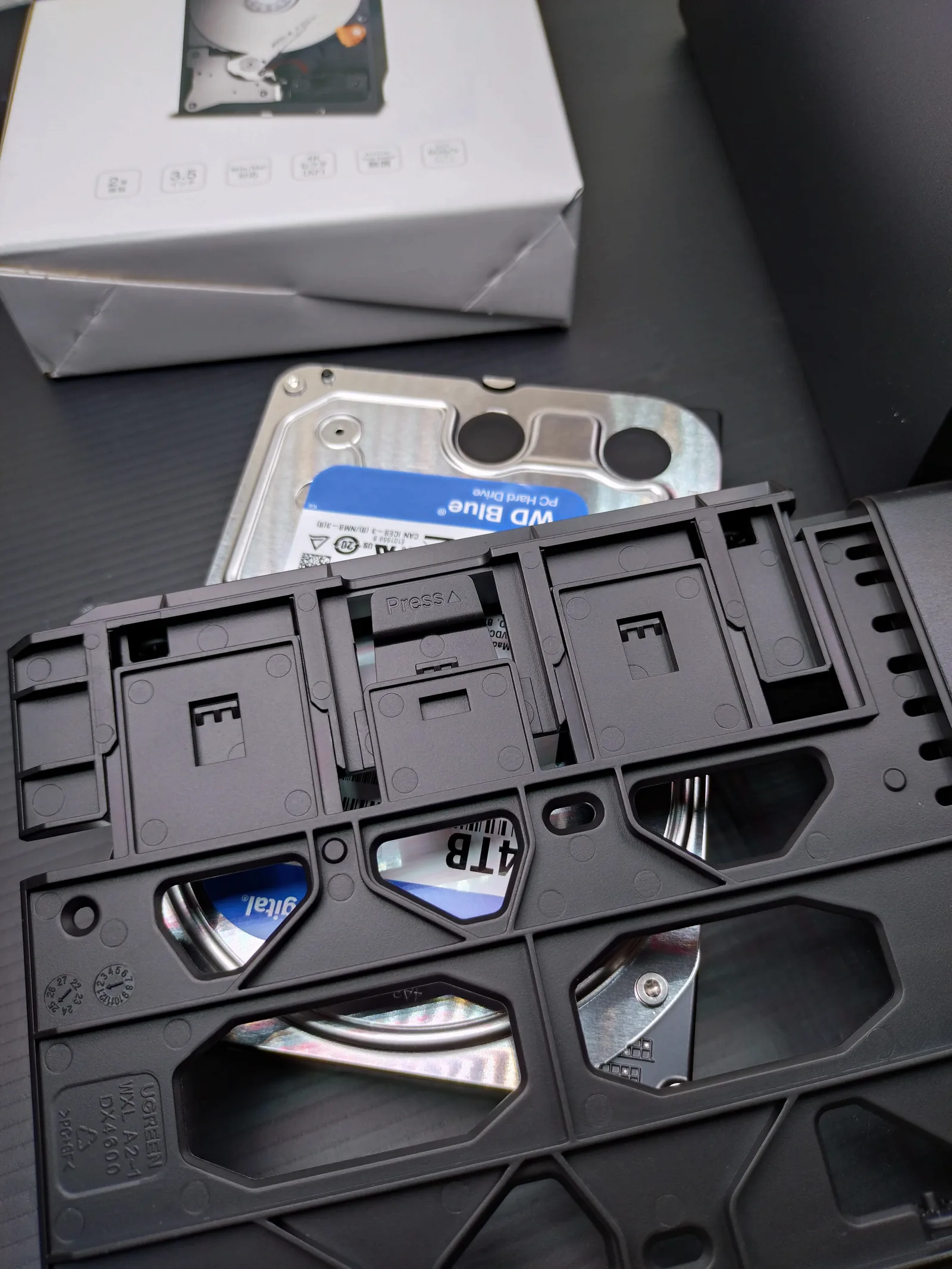 UGREEN NASync DXP2800のツールレストレイに3.5インチHDDを装着する様子。使用しているのはPC向けのWD Blue 4TB